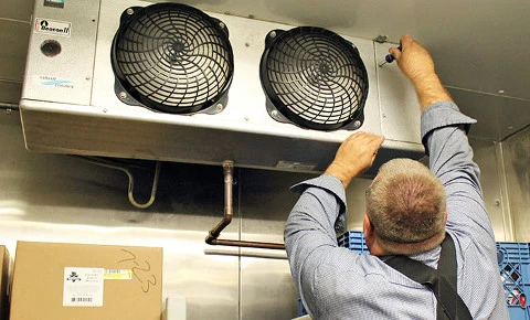 HVAC technician repairing commercial refrigeration evaporator system in South Florida